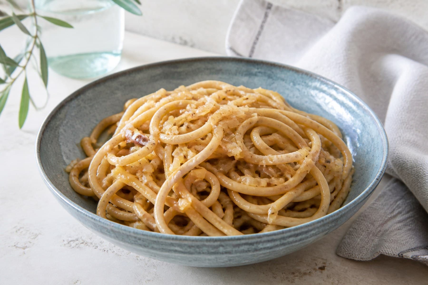 Thick bigoli pasta coated with soft golden onion and anchovy sauce