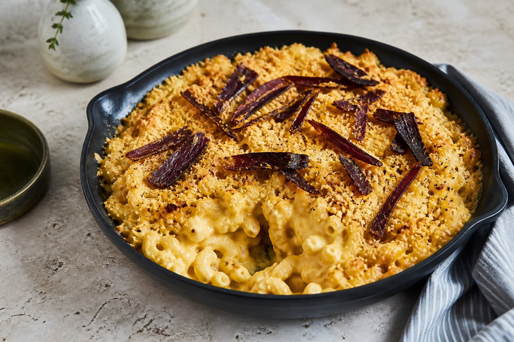 Golden biltong macaroni cheese with thin biltong strips and crisp crumb