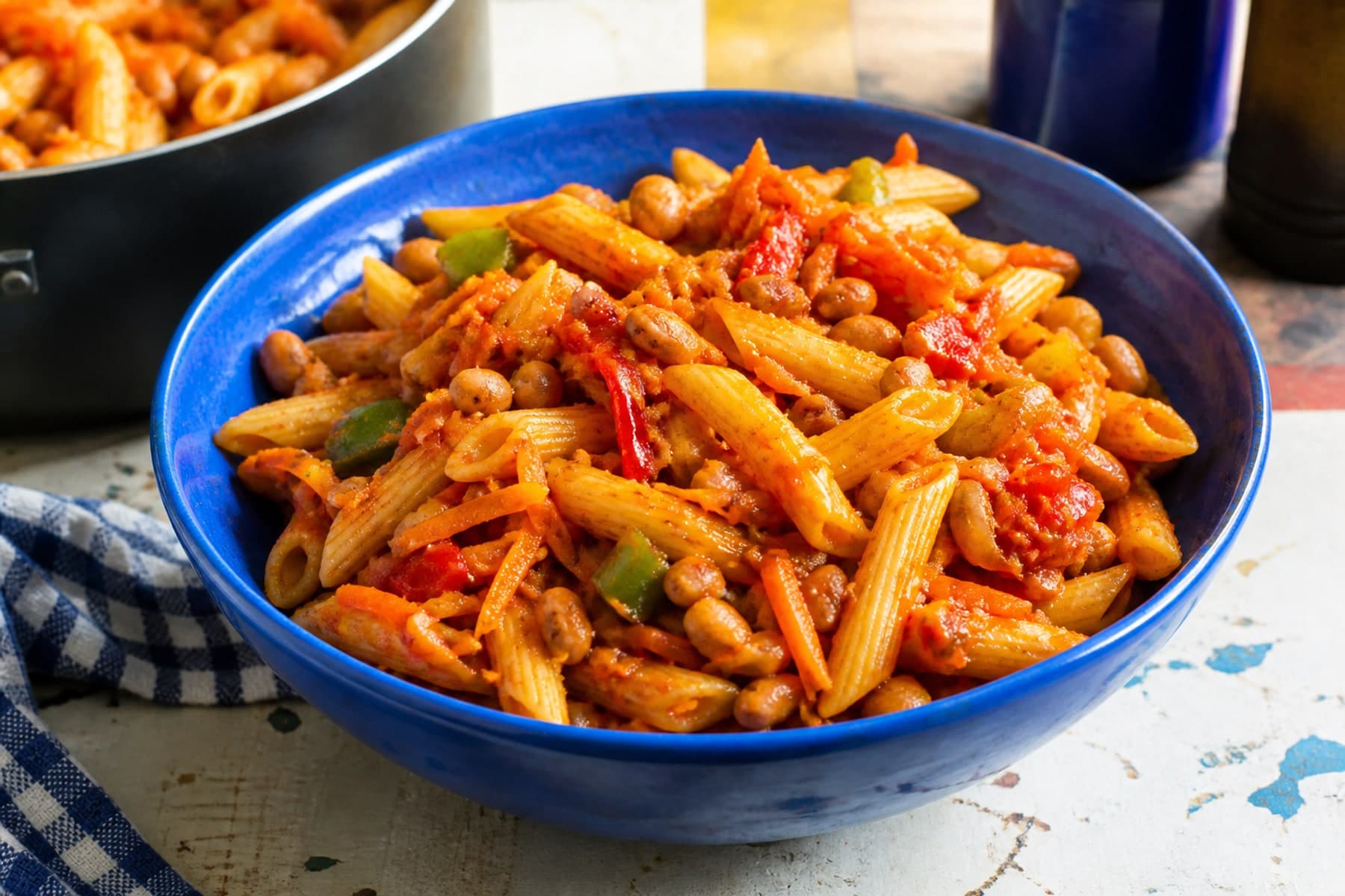 Chakalaka inspired penne with beans peppers and carrot in a vibrant ceramic bowl