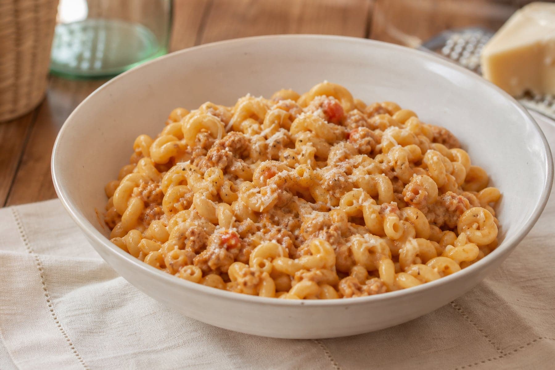 Curled gramigna pasta with crumbled sausage light tomato cream sauce and Parmesan