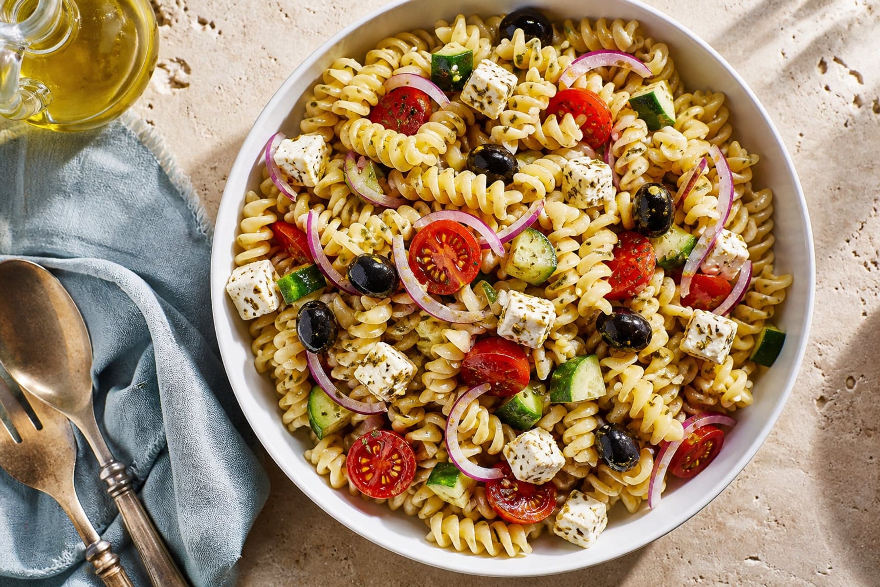 Fusilli pasta salad with cucumber tomato olives feta red onion and oregano