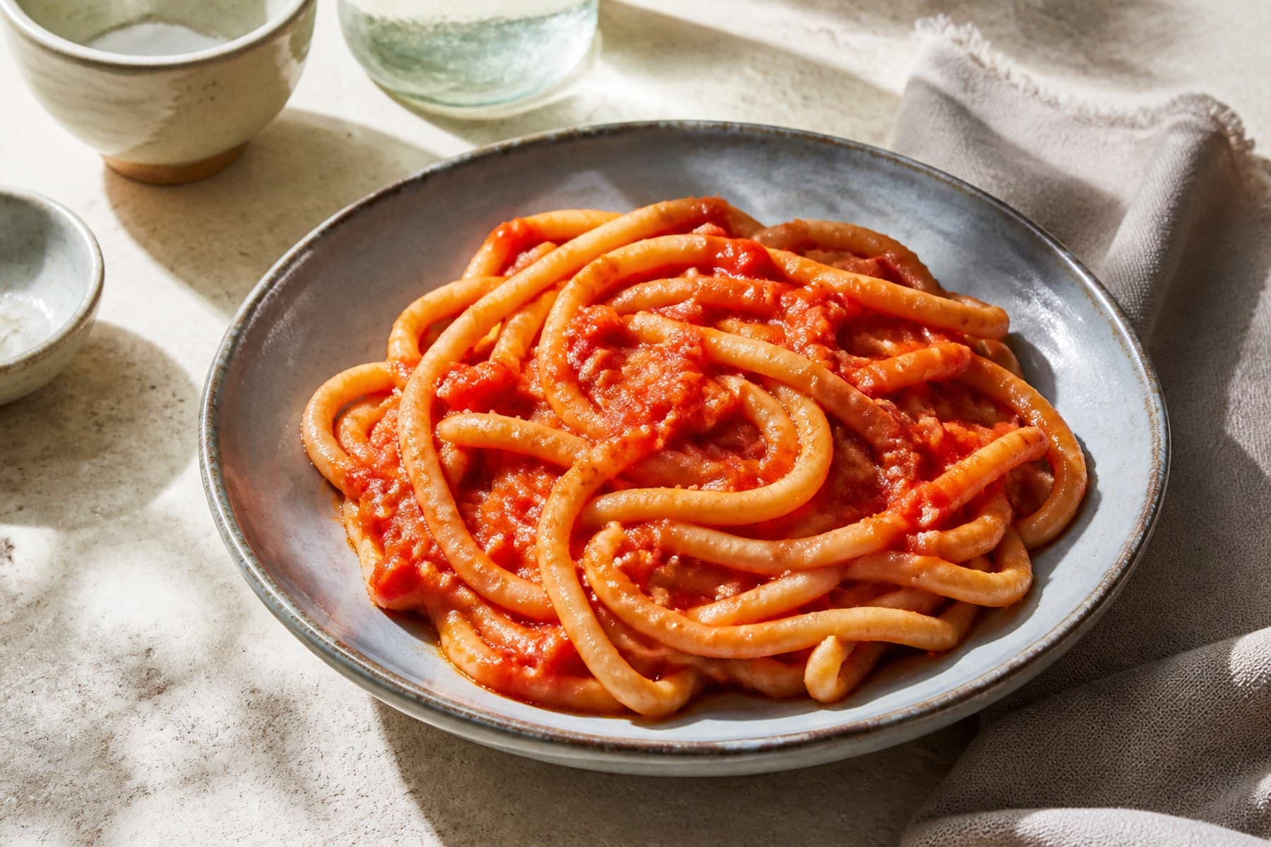 Thick hand-rolled pici pasta in bright tomato and gentle garlic sauce