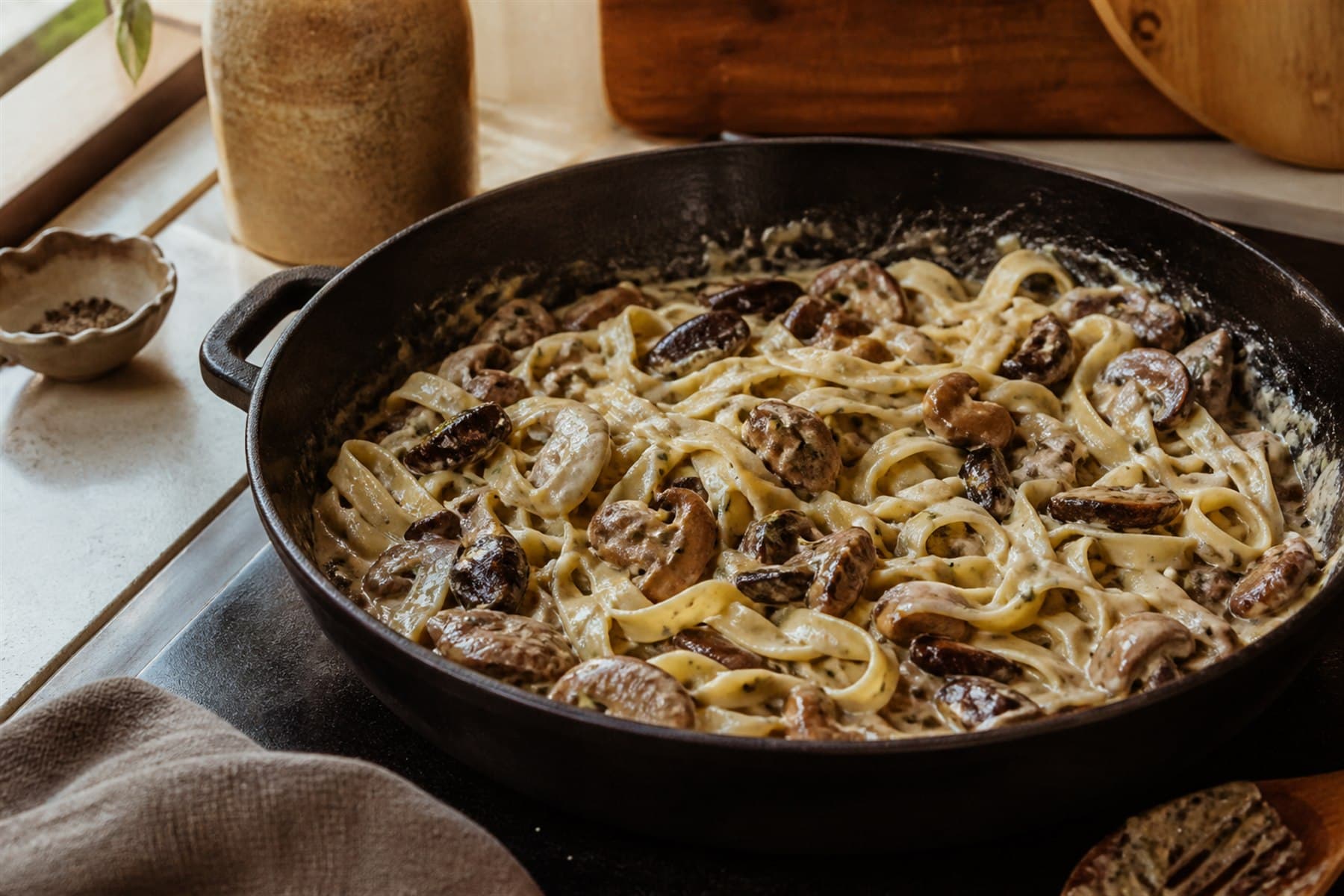 Brown mushroom cream sauce simmering in a wide skillet