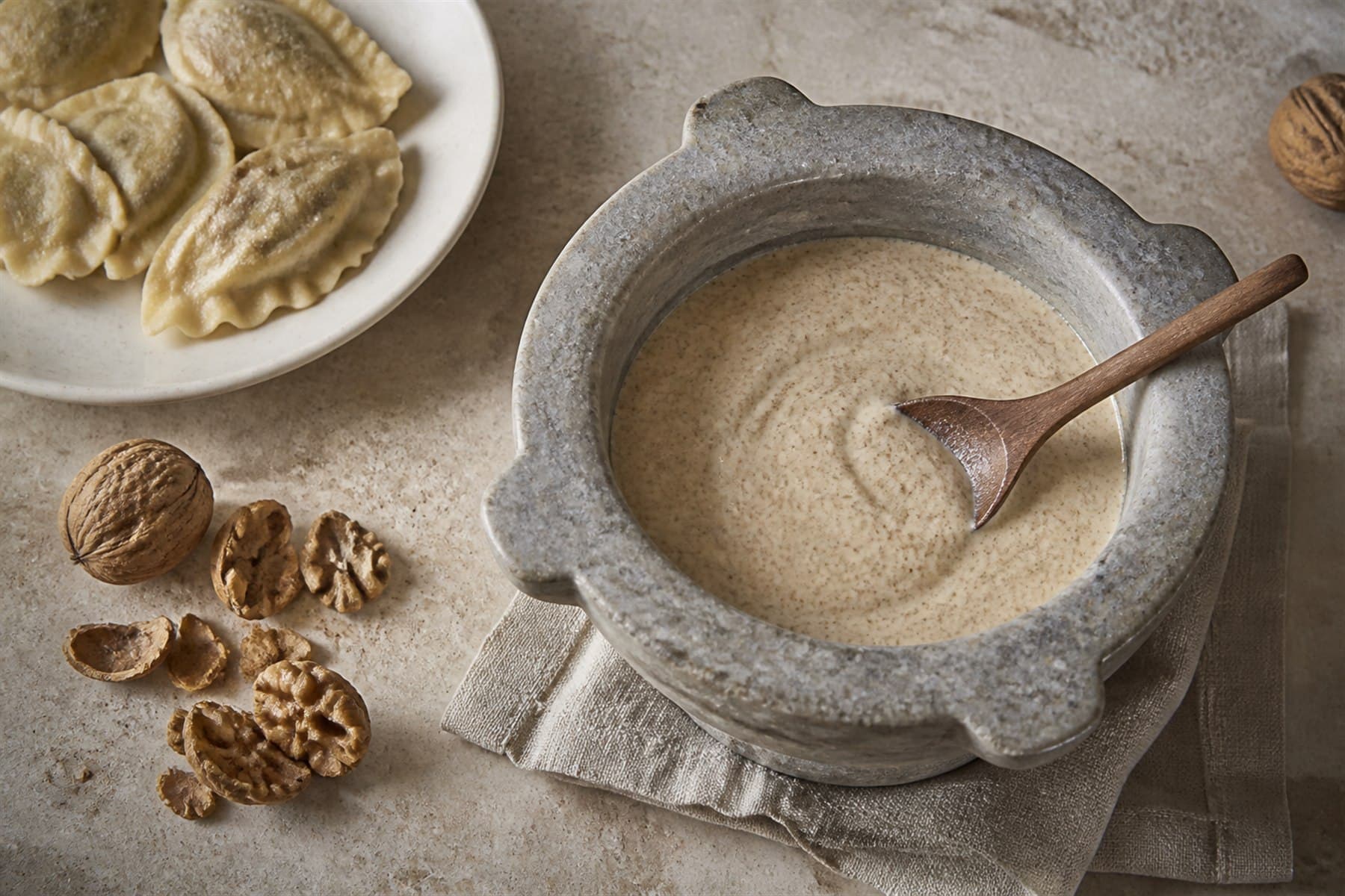 Pale textured Ligurian walnut sauce in a stone mortar