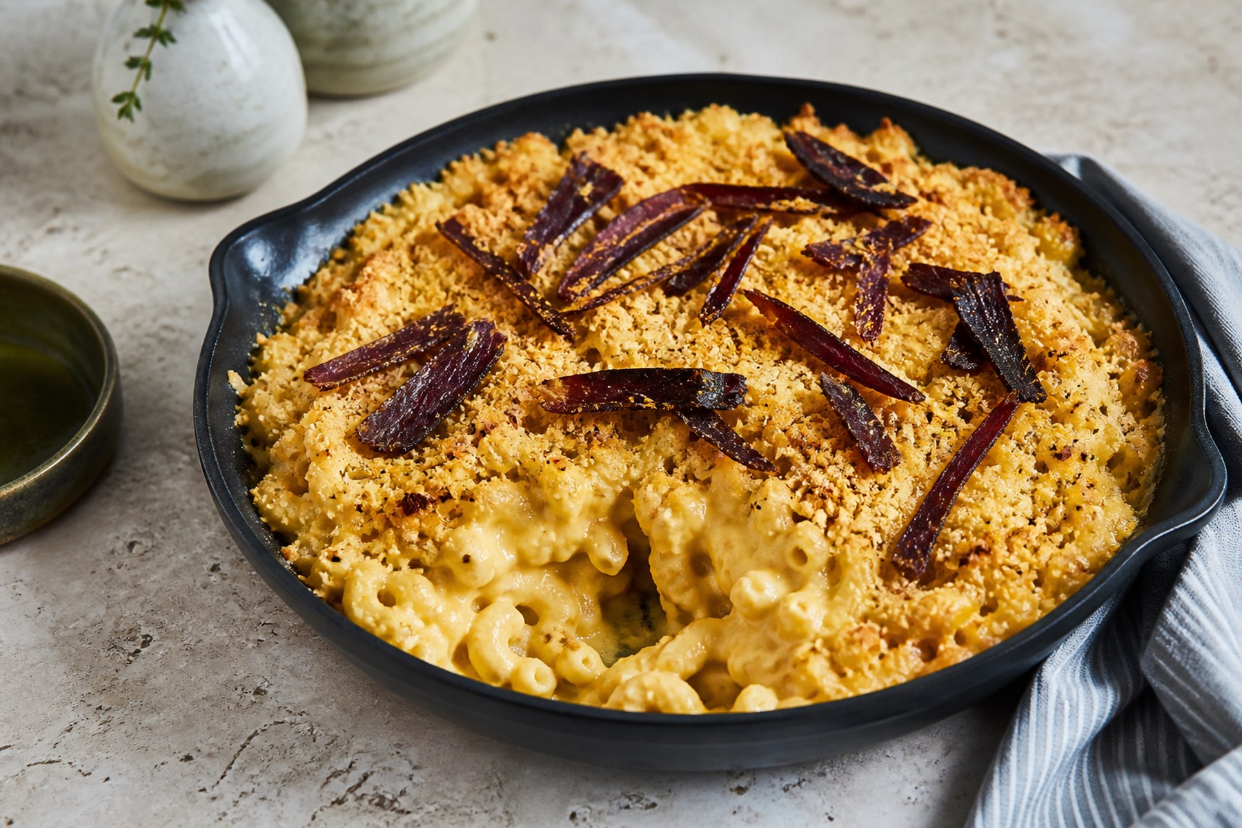 Golden biltong macaroni cheese with thin biltong strips and crisp crumb