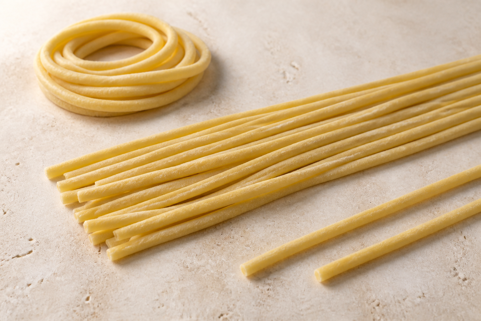 Thick solid Venetian bigoli strands showing their rough round profile on pale stone